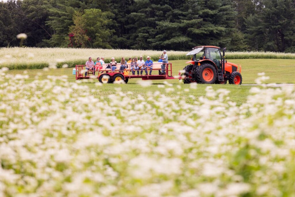 Visitors to farm participating in a wagon tour presentation.