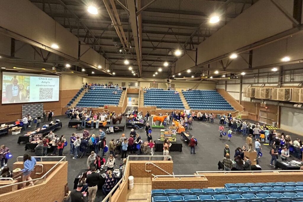 Participants visiting display tables during a horse management event in Brehm Arena